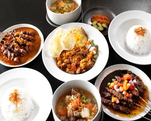 A variety of traditional Indonesian dishes served with rice